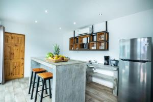 a kitchen with a counter and a refrigerator at Hotel Bamboo in Jacó