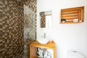 a bathroom with a sink and a shower at Hotel Bamboo in Jacó