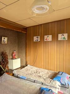 a bedroom with two beds and a wall with pictures at 水雲間民宿 in Furano