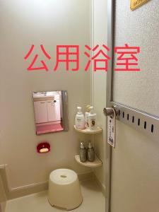 een badkamer met een wit toilet en een spiegel bij 水雲間民宿 in Furano