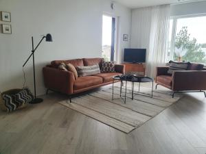 een woonkamer met een bank en een tafel bij Lovely modern 1-bedroom apartment, free parking in Reykjavík