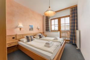 a bedroom with two beds and a large window at Resort Amadeus-Landhaus Amadeus in Gröbming
