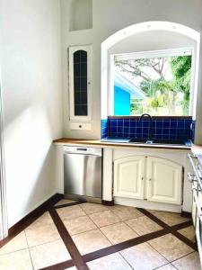a kitchen with a sink and a window at Maison La Samana in Baie-Mahault