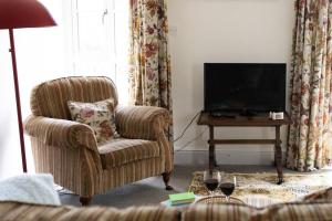 a living room with a chair and a flat screen tv at Peaceful and cosy retreat near Llandeilo in Llanfynydd