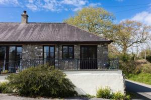 an old stone house with a balcony at Peaceful and cosy retreat near Llandeilo in Llanfynydd