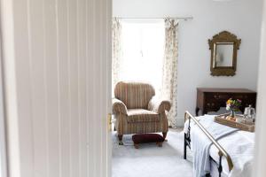 a bedroom with a chair and a bed and a window at Peaceful and cosy retreat near Llandeilo in Llanfynydd