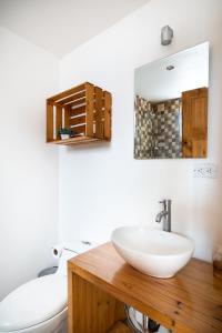 a bathroom with a sink and a toilet and a mirror at Hotel Bamboo in Jacó