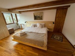 a bedroom with a bed in a room with wooden floors at Camera Zâmbru - CĂTUN in Sinaia +9 photos