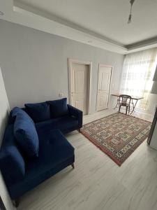 a living room with a blue couch and a table at 6 şubat apartmanı in Avanos