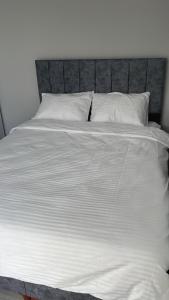 a large white bed with white sheets and pillows at 6 şubat apartmanı in Avanos