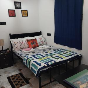 a bedroom with a bed with a blue curtain at Riverside, The European Homestay 1 and 2! Luxury and Value in Goa's delightful location in Agarvado