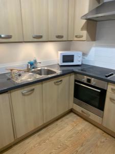 a kitchen with a sink and a microwave at Aspect apartments in Chesham