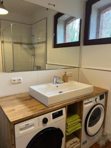 a bathroom with a sink and a washing machine at Remise an der Rennbahn in Hoppegarten