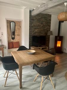 uma sala de jantar com uma mesa de madeira e cadeiras em Maison individuelle em Villecomtal-Sur-Arros