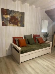 a bed with colorful pillows on it in a room at Maison individuelle in Villecomtal-Sur-Arros