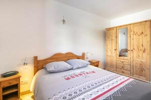 a bedroom with a large bed and a wooden cabinet at Chalet Chez Maxime Hameau l’Archaz Valloire in Valloire