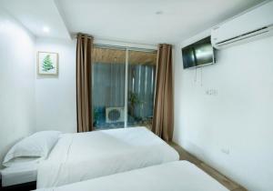 a bedroom with two beds and a window at Hotel Bamboo in Jacó +16 photos