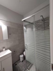uma casa de banho com uma cabina de duche em vidro e um WC. em Syggrou Street Studio em Tessalônica