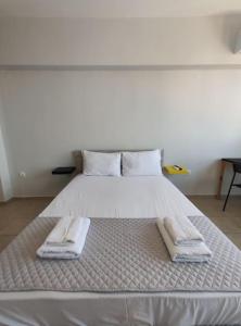 uma grande cama branca com duas toalhas em Syggrou Street Studio em Tessalônica