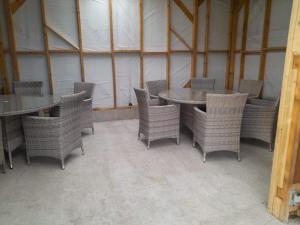 a dining room with wicker chairs and tables in a building at Cornish Skies Glamping in Pool