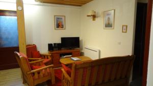 sala de estar con TV, mesa y sillas en Chalet la Bise, en La Plagne Tarentaise