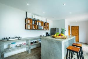 una cocina con una barra con un bol de fruta. en Hotel Bamboo en Jacó