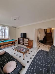 ein Wohnzimmer mit einer Couch und einem Billardtisch in der Unterkunft Grande Maison meublée tout équipé Wifi, Télé, Billard - Demeure de 196 m2 à Tain l'hermitage - 5 Chambres - 12 Couchages in Tournon-sur-Rhône