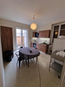 ein Wohnzimmer mit Tisch und Küche in der Unterkunft Grande Maison meublée tout équipé Wifi, Télé, Billard - Demeure de 196 m2 à Tain l'hermitage - 5 Chambres - 12 Couchages in Tournon-sur-Rhône + 30 Fotos