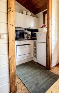 eine Küche mit einem Kühlschrank und einem Herd in der Unterkunft Lomariihi 2 in Muurame