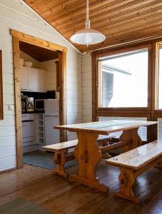 eine Küche mit einem Holztisch und Bänken in einem Zimmer in der Unterkunft Lomariihi 2 in Muurame