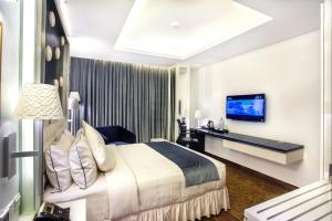a hotel room with a bed and a desk at Grace 21 Smart Hotel in Dhaka