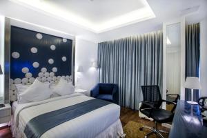 a hotel room with a bed and a blue chair at Grace 21 Smart Hotel in Dhaka