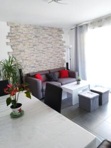 - un salon avec un canapé et un mur en briques dans l'établissement Beau T3 + clim + parking Saint Cyr sur mer, à Saint-Cyr-sur-Mer
