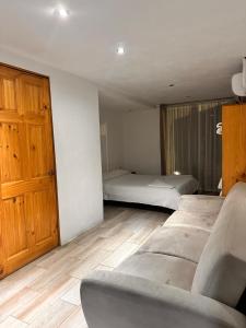 a bedroom with two beds and a couch in it at Hotel Bamboo in Jacó