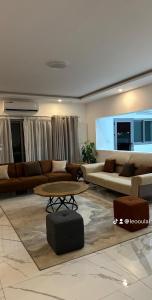 a living room with couches and a table in a room at Residence Roume Abidjan Plateau in Abidjan