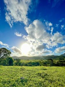 un campo de hierba con el sol en el cielo en Grande chalé luxo refúgio a 10min de Balneário Camboriú, en Camboriú
