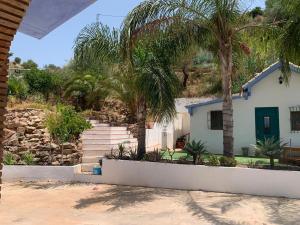 a house with palm trees in front of it at Casa Rural Los Almendros in Málaga