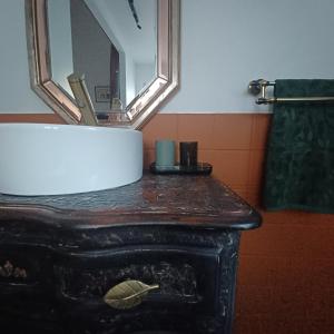 a bathroom with a vanity with a mirror and a fireplace at Le Banellou in Quimper