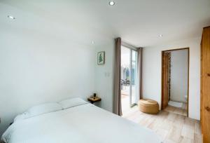 a bedroom with a white bed and a large window at Hotel Bamboo in Jacó