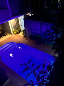 a swimming pool with blue lighting in a building at Hotel Bamboo in Jacó