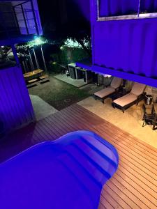 a blue room with a bed on a deck at night at Hotel Bamboo in Jacó