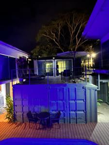 a house with purple lights on a deck at night at Hotel Bamboo in Jacó
