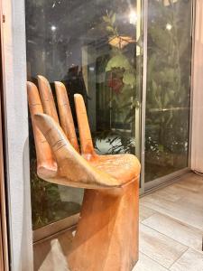 a wooden chair sitting in front of a window at Hotel Bamboo in Jacó