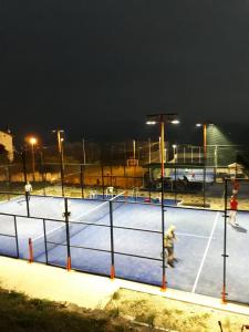 un gruppo di persone che giocano a tennis su un campo da tennis di notte di Agriturismo Alta Collina a Benevento