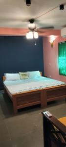un grande letto in una stanza con una parete blu di The Tea Road Hotel and Restaurant - Auroville Beach a Kottakupam