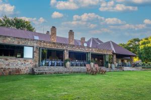 a brick building with chairs in a yard at Walkersons Hotel & Spa in Dullstroom