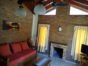 ein Wohnzimmer mit einem Sofa und einem Kamin in der Unterkunft CABAÑAS LOS ARRAYANES in Chascomús