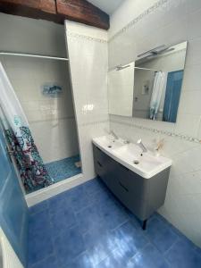 uma casa de banho branca com um lavatório e um chuveiro em Maison a deux pas de Perigueux quartier calme. em Coulounieix-Chamiers