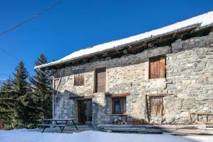 a stone building with a picnic table in front of it at Chalet Chez Maxime Hameau l’Archaz Valloire in Valloire