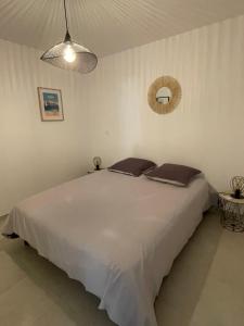 a bedroom with a large white bed with two pillows at Loc A Machja Fiurita 3 appartements - Pietrosella et Ajaccio in Pietrosella